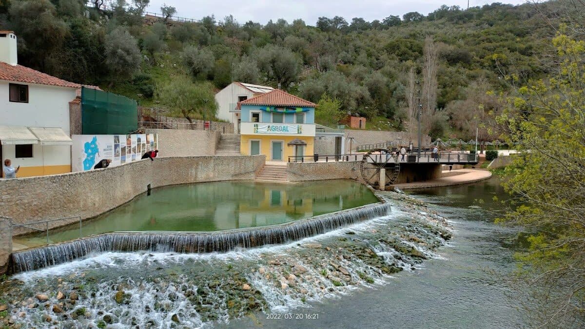 Praia fluvial do Agroal com águas cristalinas e zona de banhos acessível no interior de Portugal